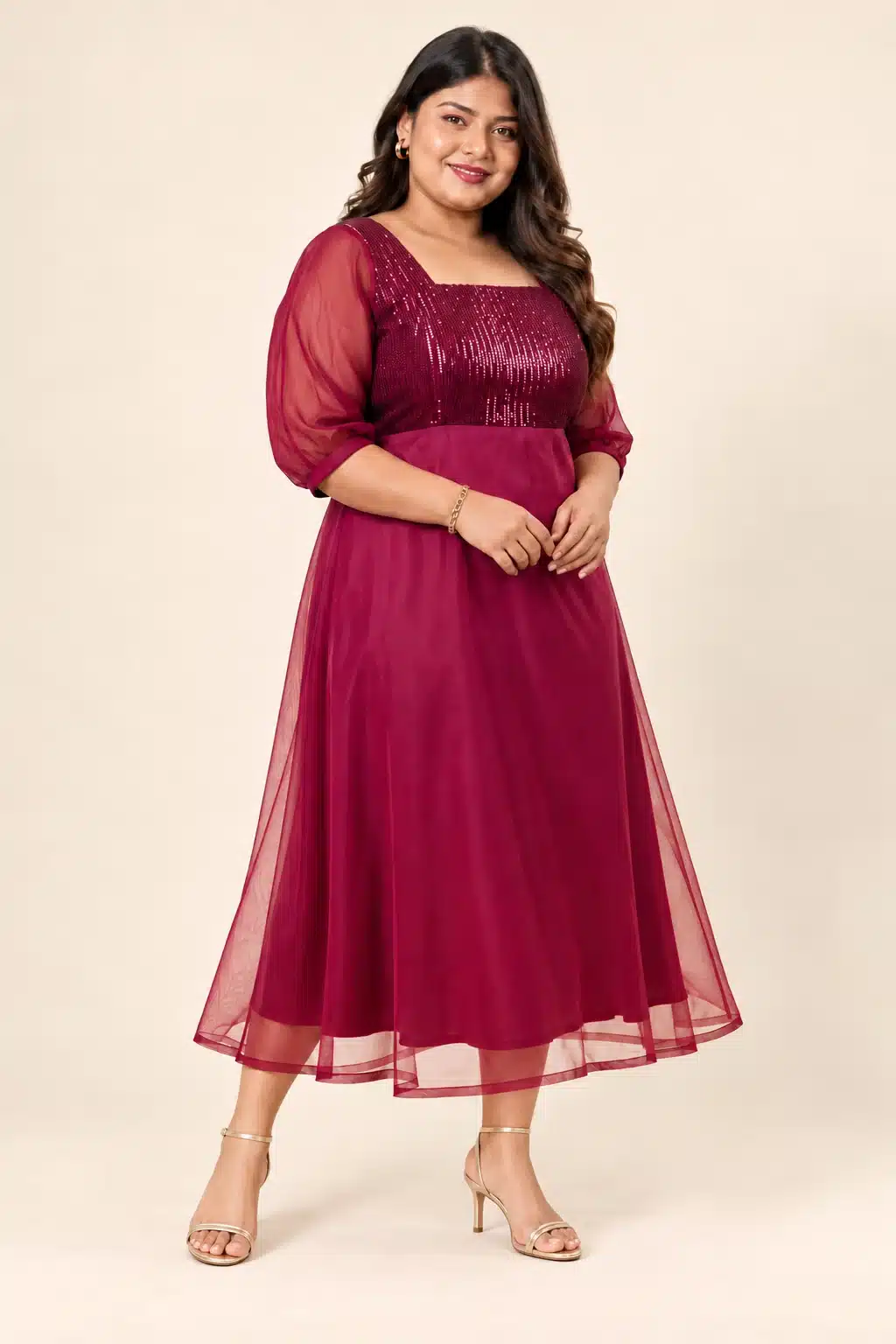 Three-quarter view of a plus-size model wearing the Maroon Sequin Elegance Gown with sheer sleeves and a flared skirt
