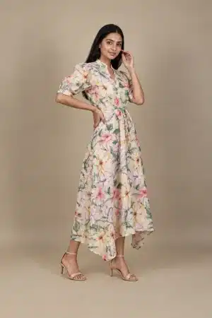 Pastel Floral High Low Dress in beige with multicolour flowers, three-quarter view with hand at waist.