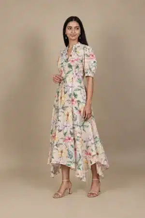 Pastel Floral High Low Dress in beige with multicolour flowers, three-quarter standing view.